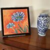 Série Petits formats, mise en situation du tableau "Duo d'agapanthes", bleu et orange, acrylique sur toile par Meryl artiste peintre